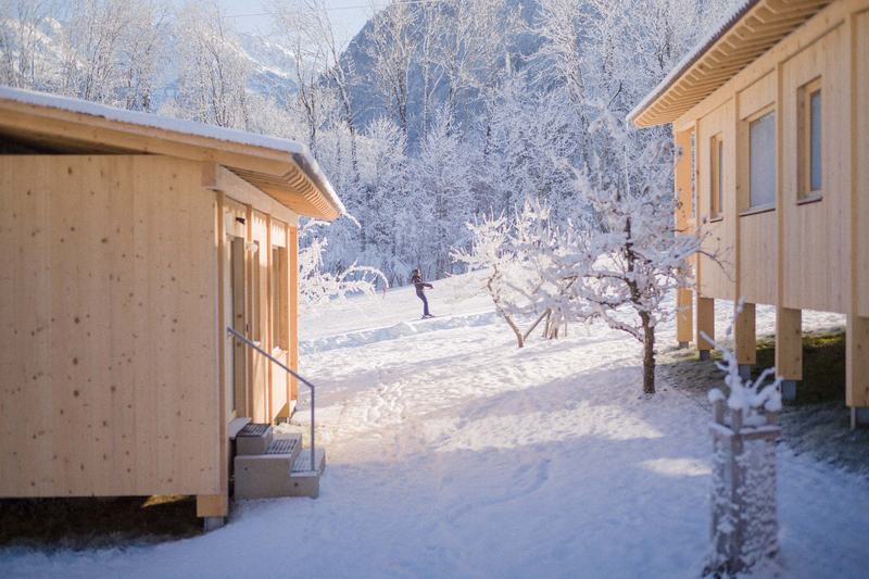 Verschneiter Obstgarten zwischen zwei Chalets